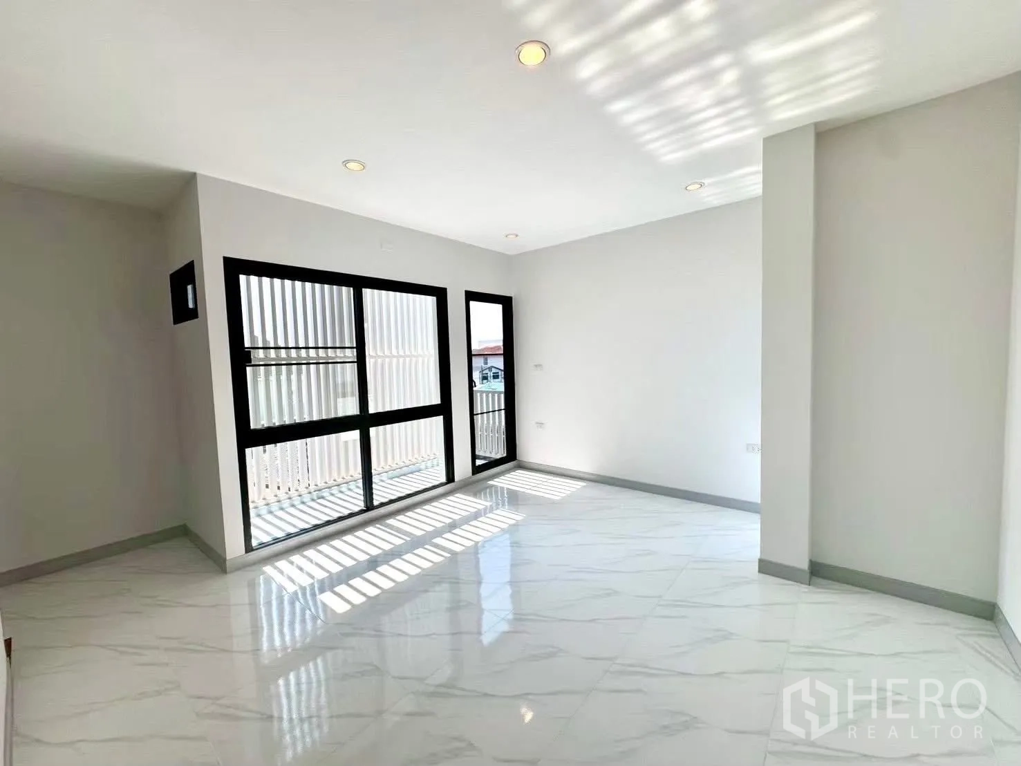 Home Office for rent in Wang Thonglang, Bangkok - Sunlit open room with floor-to-ceiling windows and glossy tile flooring.