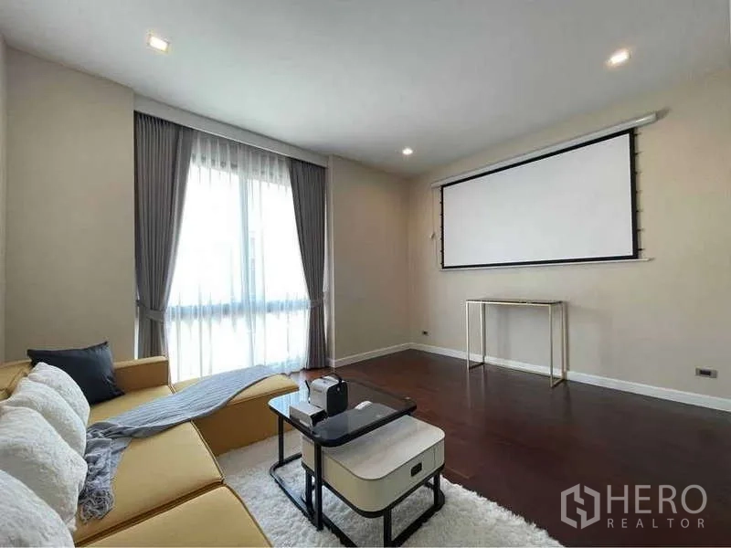 Detached House for rent in Bang Sue, Bangkok - Cozy media room with projector screen, sofa and wood floors in a Bang Sue house.