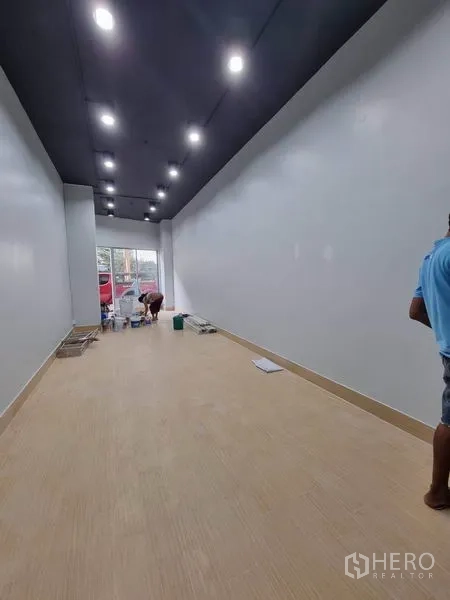 พื้นที่ขายปลีก ให้เช่าในKhlong Toei, Bangkok - พื้นที่ภายในยาวต่อเนื่อง พื้นลายไม้ ไฟดาวน์ไลท์เต็มแนว และหน้าต่างกระจกด้านหน้า