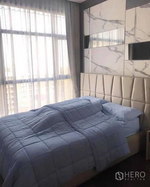 公寓 出租或出售在Watthana, Bangkok - 次卧设大理石纹装饰墙、落地窗与软包床头。