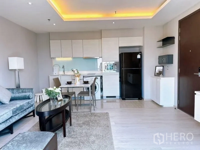 คอนโด ให้เช่าในWatthana, Bangkok - โถงนั่งเล่นแบบเปิดโล่งกับครัวบิวท์อิน เครื่องซักผ้า ตู้เย็น และชุดทานอาหารกะทัดรัด