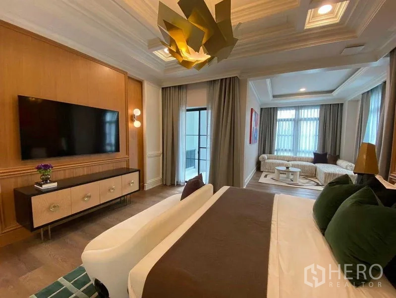 Detached House for sale in Saphan Sung, Bangkok - Spacious master bedroom with TV wall, seating nook and sculptural ceiling light.