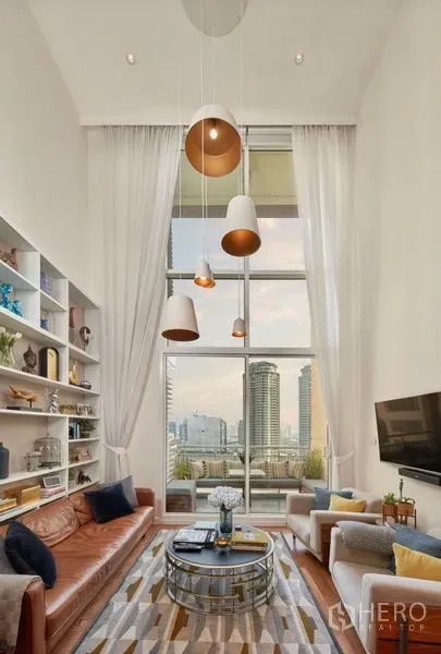 คอนโด ให้เช่าหรือขายในSathon, Bangkok - พื้นที่นั่งเล่นพร้อมหน้าต่างสูงจรดเพดาน ระเบียง วิวสกายไลน์ โซฟาคู่ และผ้าม่านสีขาว