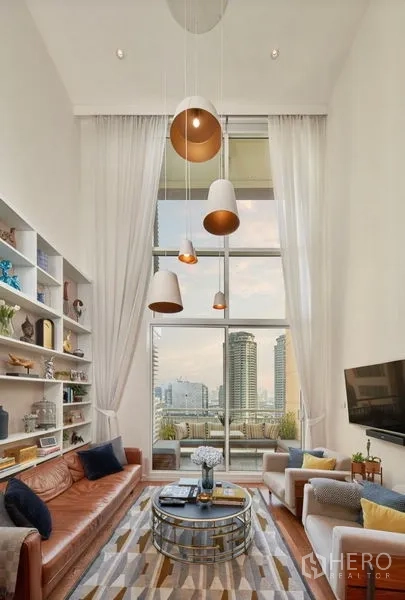 คอนโด ให้เช่าหรือขายในSathon, Bangkok - พื้นที่นั่งเล่นพร้อมหน้าต่างสูงจรดเพดาน ระเบียง วิวสกายไลน์ โซฟาคู่ และผ้าม่านสีขาว