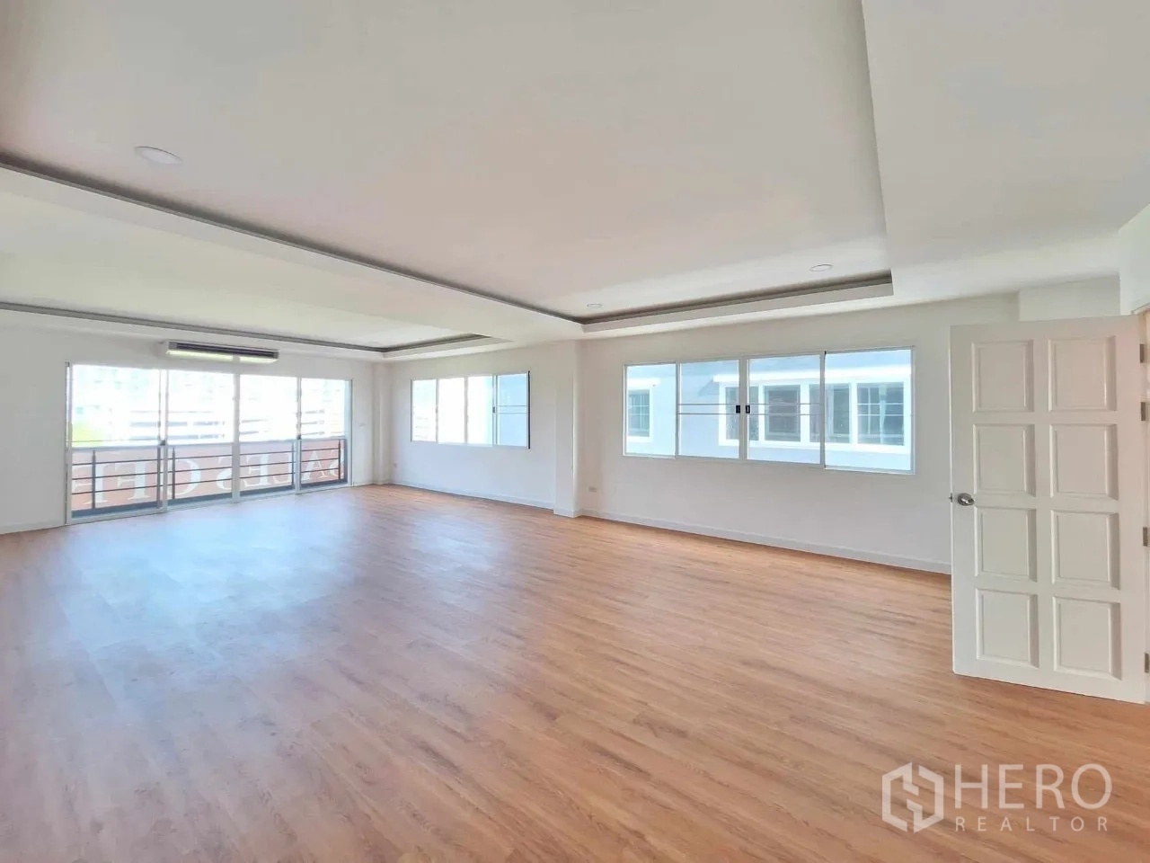 Home Office for sale in Bueng Kum, Bangkok - Bright upper-floor office room with wood flooring, sliding doors to a balcony and wide windows.