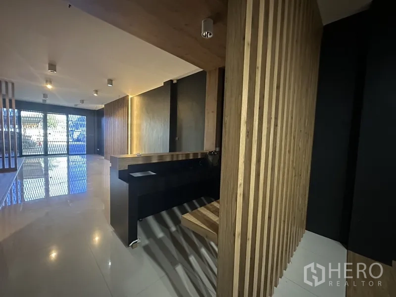 สำนักงานที่บ้าน ให้เช่าในPhra Khanong, Bangkok - เคาน์เตอร์ต้อนรับไม้และผนังซี่ไม้ หันหน้าไปทางประตูทางเข้า