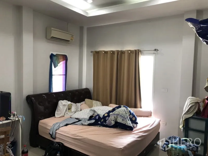 บ้าน ขายในLam Luk Ka, Pathum Thani - ห้องนอนอบอุ่นพร้อมเตียงและผ้าม่านสีเบจ