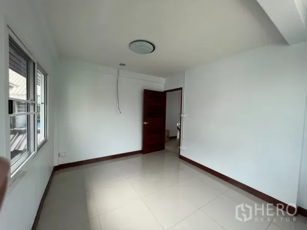 บ้าน ให้เช่าในKhlong Toei, Bangkok - ห้องโล่งสว่าง ผนังสีขาว พื้นกระเบื้องเงา มีหน้าต่างและประตูไม้