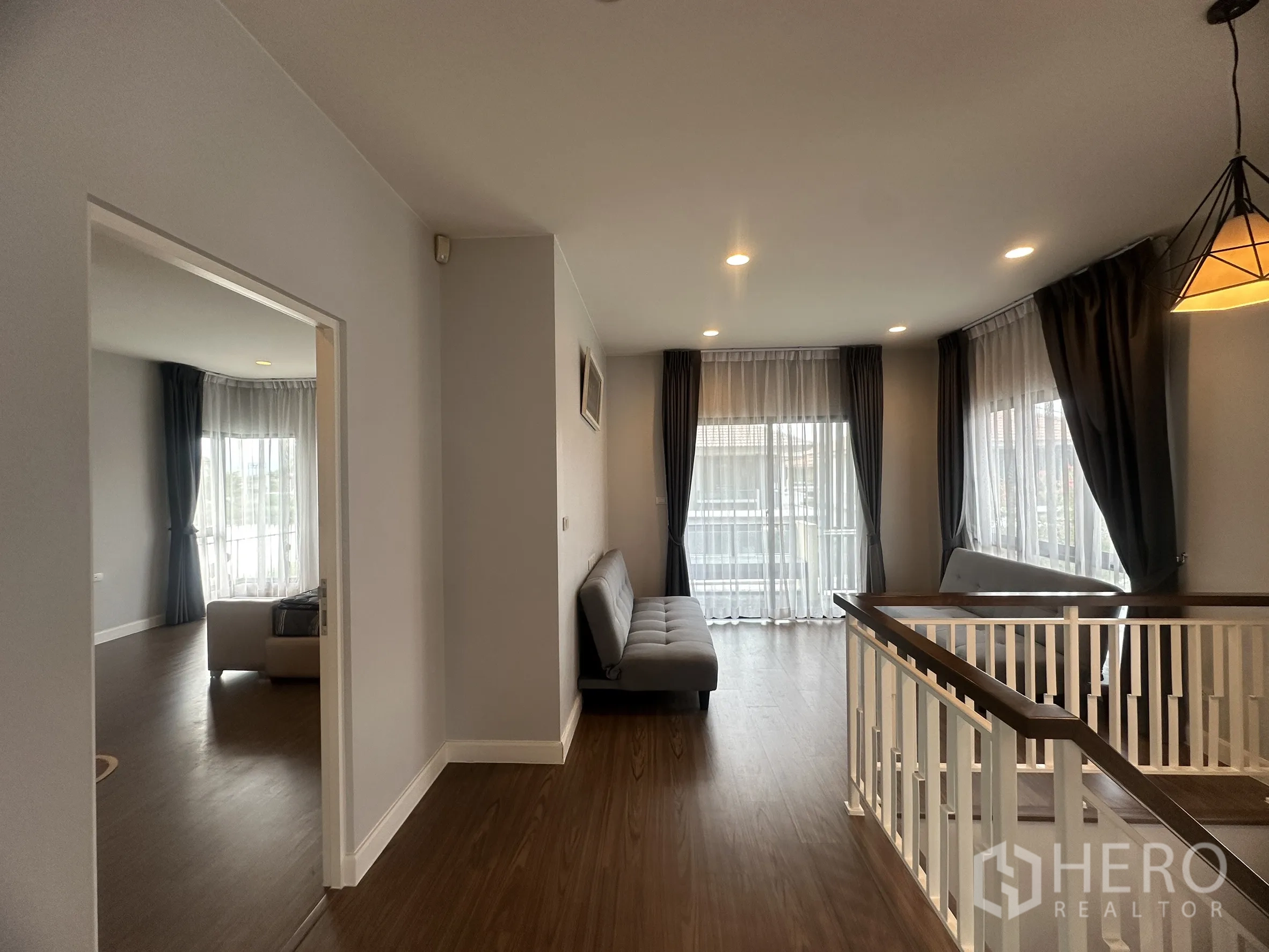 独栋房屋 for rent or sale in Lam Luk Ka, Pathum Thani - 宽敞的二楼走廊，带栏杆与落地窗。