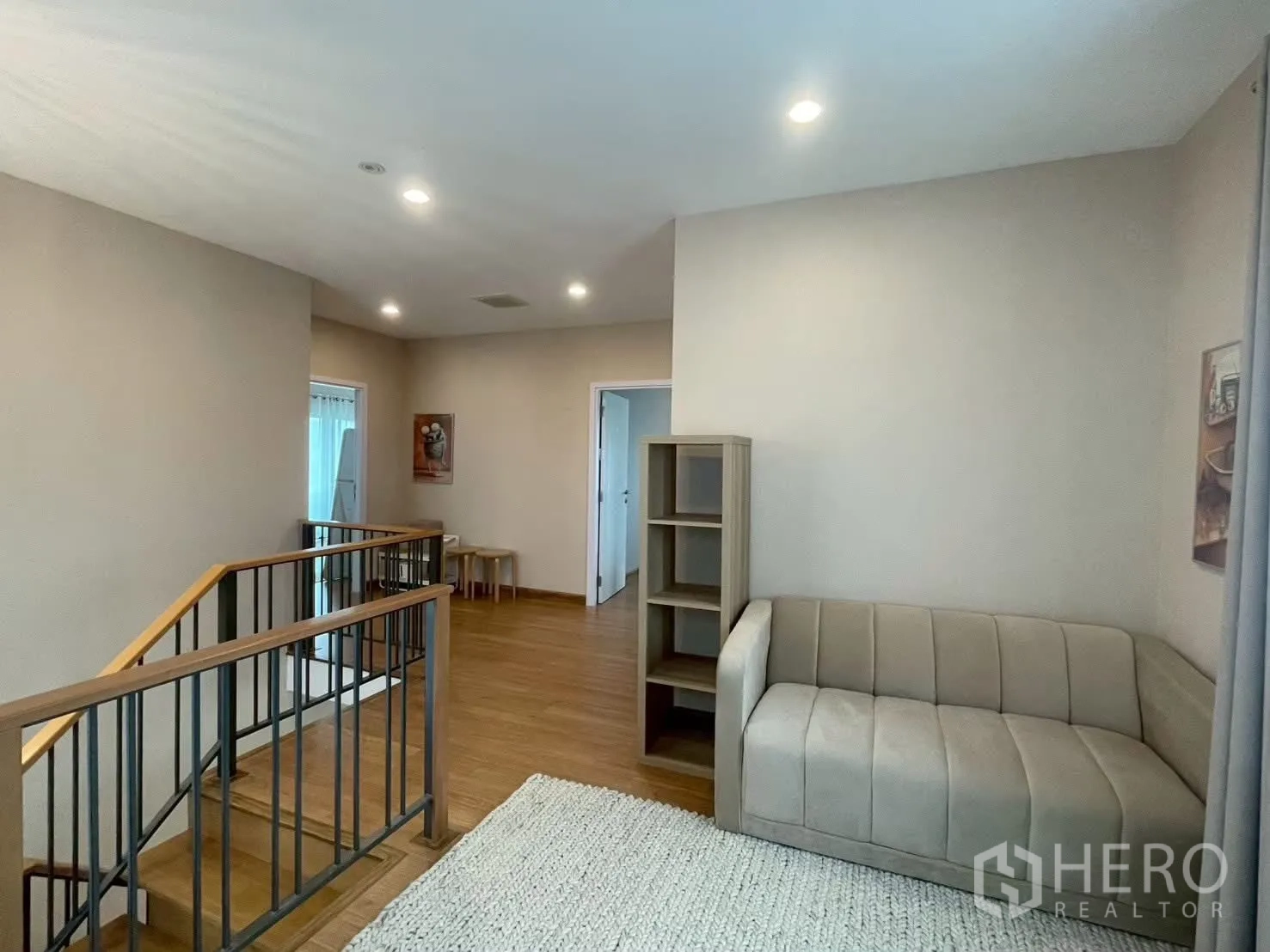 Detached House for rent in Bang Phli, Samut Prakan - Upper landing lounge with sofa, bookshelf and metal railing.