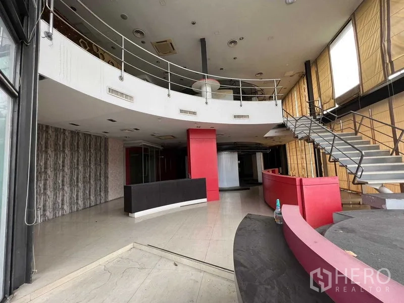 零售空间 出租 - 挑高双层门厅，弧形接待台、楼梯和大幅玻璃窗