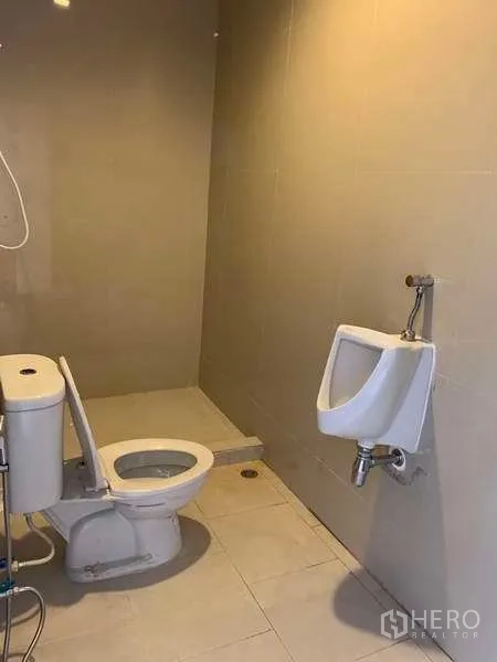 货栈 出租在Bang Phli, Samut Prakan - 仓库内整洁的瓷砖卫生间，配坐便器、小便斗和淋浴区。