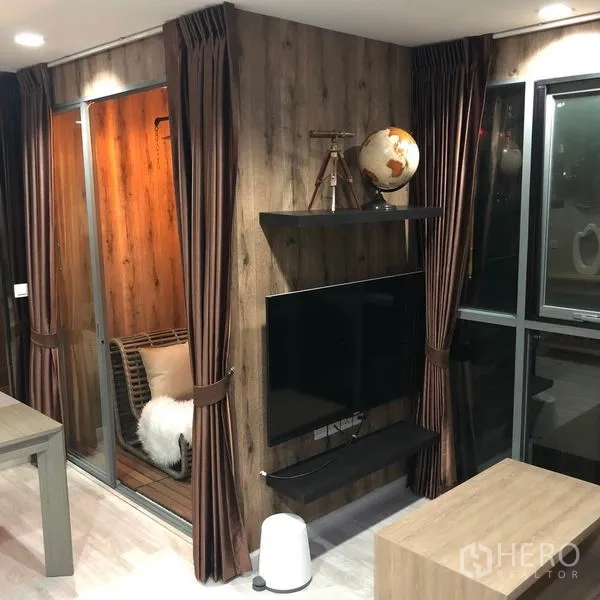 Condominium for rent or sale in Phra Khanong, Bangkok - TV wall with wood cladding, floating shelf and sliding glass door to the enclosed balcony.