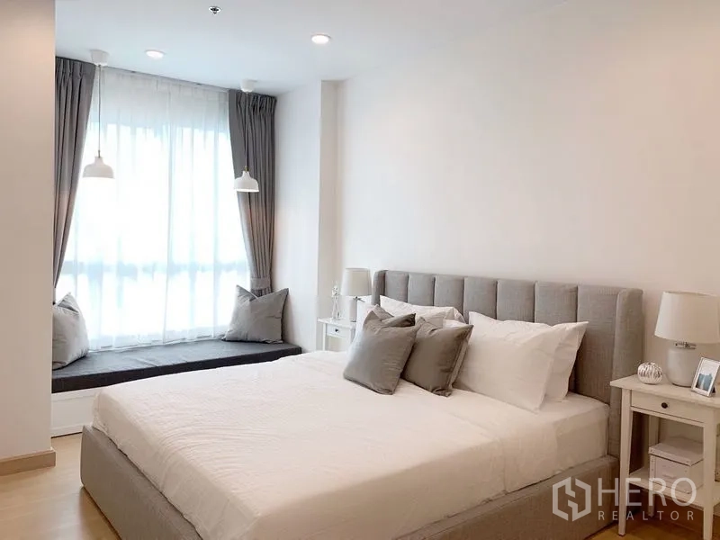 Condominium for sale in Yan Nawa, Bangkok - Cozy bedroom corner with king bed, bedside tables and a cushioned window bench.
