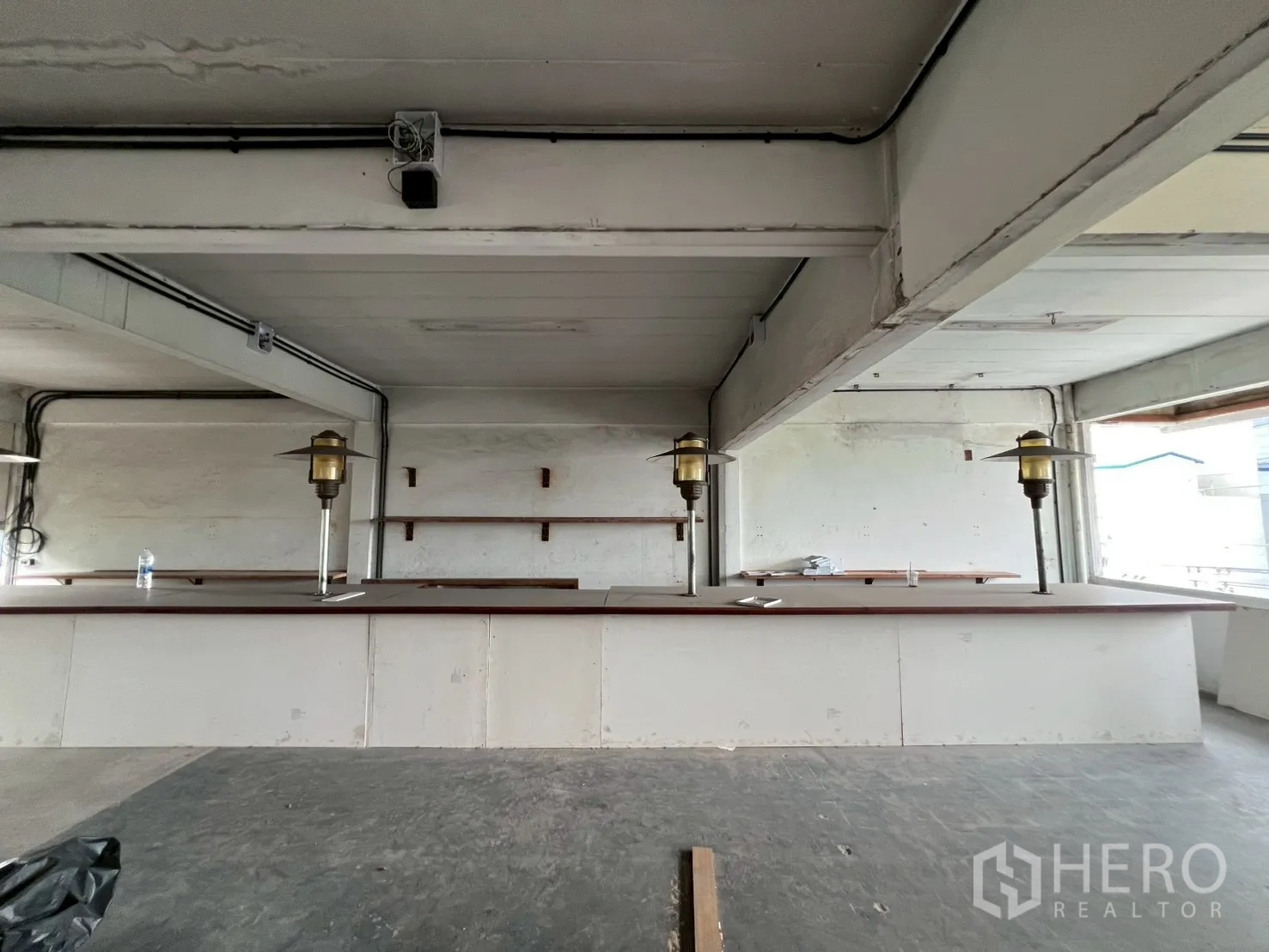 零售空间 出租在Watthana, Bangkok - 正面视角的超长吧台，墙面搁架与工业风天花。