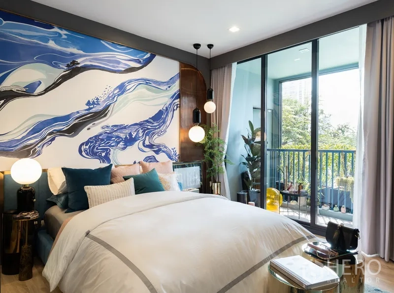 公寓 出售在Ratchathewi, Bangkok - 温馨卧室，醒目的蓝色主墙，滑门通往绿景阳台。