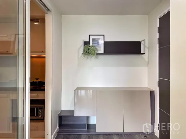 คอนโด ให้เช่าในWatthana, Bangkok - มุมห้องนั่งเล่นมีตู้บิลท์อินและชั้นลอย ประตูบานเลื่อนสู่ครัวแยก พื้นไม้โทนเข้ม คอนโดใกล้ BTS ทองหล่อ