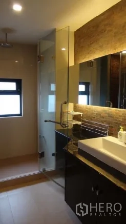 Condominium for rent or sale in Sathon, Bangkok - Modern bathroom with glass-enclosed shower, wide mirror, and illuminated vanity.