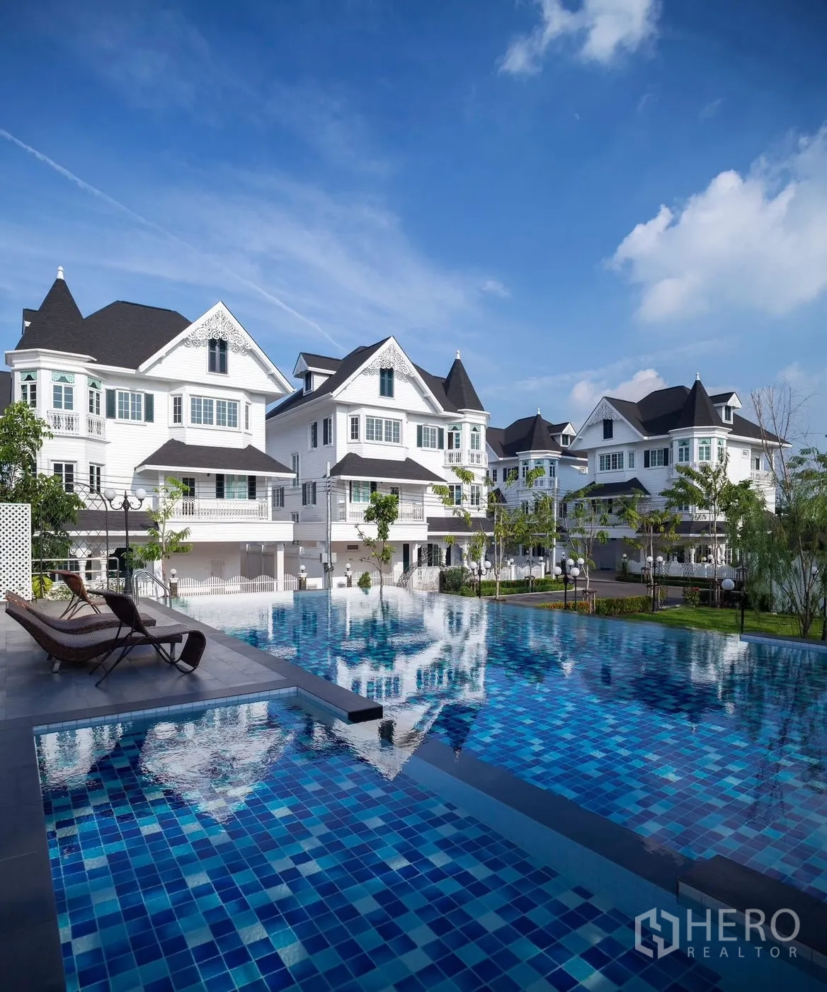 Detached House for rent in Bang Na, Bangkok - Resort-style community pool with white detached houses in the background.
