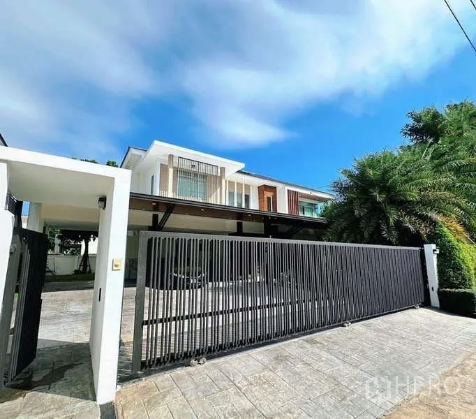 Detached House for rent or sale in Bang Phli, Samut Prakan - Street-facing modern facade with long driveway and secure sliding gate.