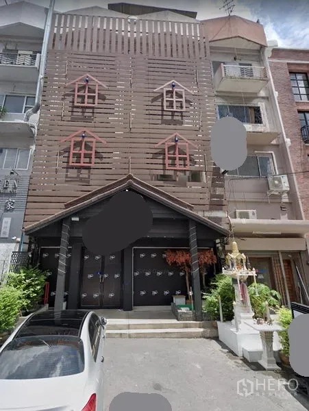 零售空间 出租在Watthana, Bangkok - 通罗区多层临街商业楼外立面，木质格栅与三角屋檐，前方小型空地。