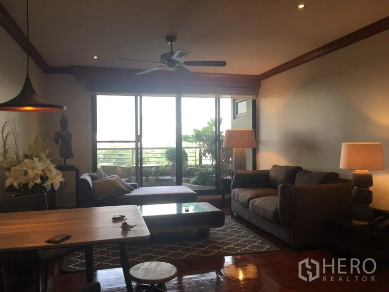 公寓 出租在Sathon, Bangkok - 客厅通过落地推拉门连通种满绿植的阳台，采光充足。