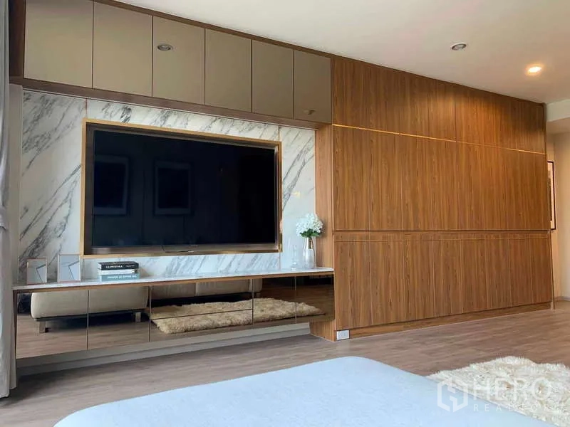 Condominium for rent - Custom TV wall with marble feature panel, large flat-screen and extensive wood built-in cabinets.