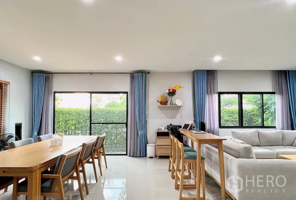 บ้าน ให้เช่าหรือขายในLam Luk Ka, Pathum Thani - ชั้นล่างกว้างขวาง โต๊ะอาหารยาว เคาน์เตอร์บาร์ และกระจกบานใหญ่จรดพื้น