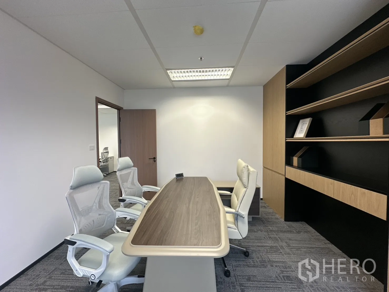 办公室 for rent in Pathum Wan, Bangkok - 私密会议室配木质会议桌、白色网椅与内置书架。
