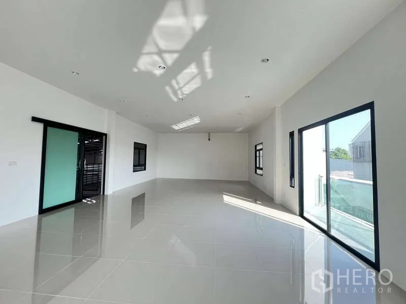 คลังสินค้า ให้เช่าหรือขาย - สำนักงานกว้างมีสกายไลท์ ประตูกระจกบานเลื่อน และหน้าต่างกรอบดำ