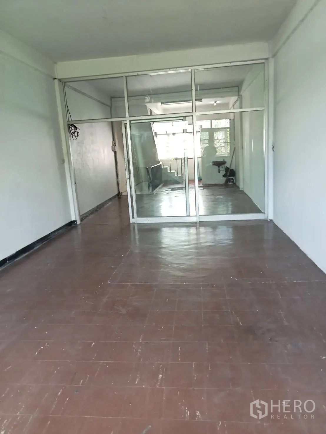 อาคารพาณิชย์ ให้เช่าในPhra Khanong, Bangkok - ห้องชั้นบน พื้นกระเบื้องสีน้ำตาล พร้อมผนังกั้นกระจกเต็มบานใกล้บันได