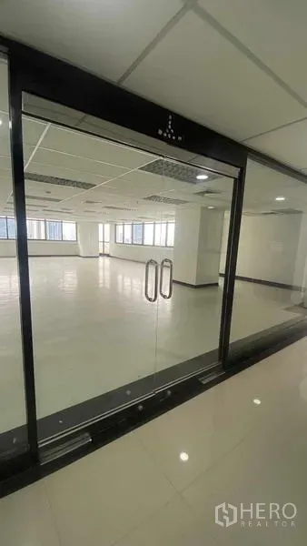 สำนักงาน ให้เช่าหรือขายในPhaya Thai, Bangkok - ประตูกระจกกรอบอลูมิเนียมสีดำ เปิดสู่พื้นที่สำนักงานว่าง พื้นเงาและไฟฝ้าแบบกริด