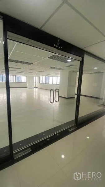 สำนักงาน ให้เช่าหรือขายในPhaya Thai, Bangkok - ประตูกระจกกรอบอลูมิเนียมสีดำ เปิดสู่พื้นที่สำนักงานว่าง พื้นเงาและไฟฝ้าแบบกริด