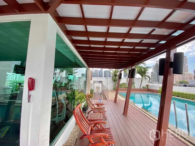 คอนโด ให้เช่าในWatthana, Bangkok - ดาดฟ้าข้างสระว่ายน้ำพร้อมศาลาไม้ เก้าอี้นั่งเล่น และวิวสกายไลน์ติดห้องฟิตเนส