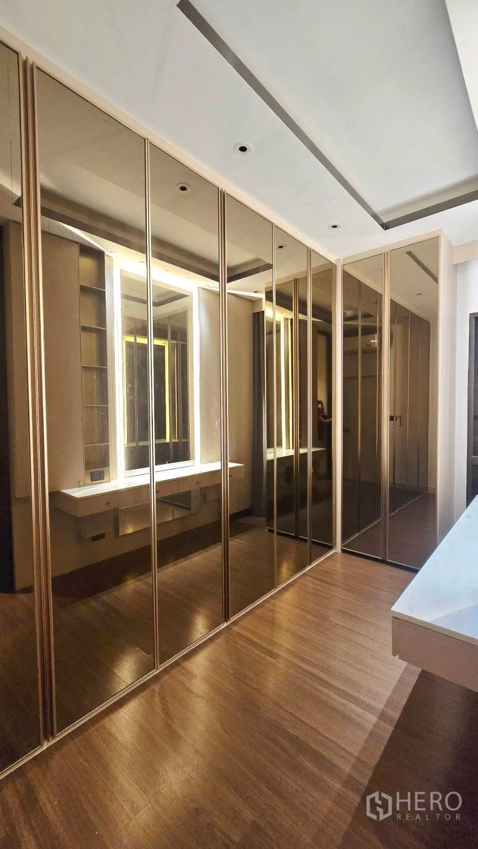 Detached House for rent in Prawet, Bangkok - Walk-in dressing area with mirrored wardrobes and a lighted vanity.