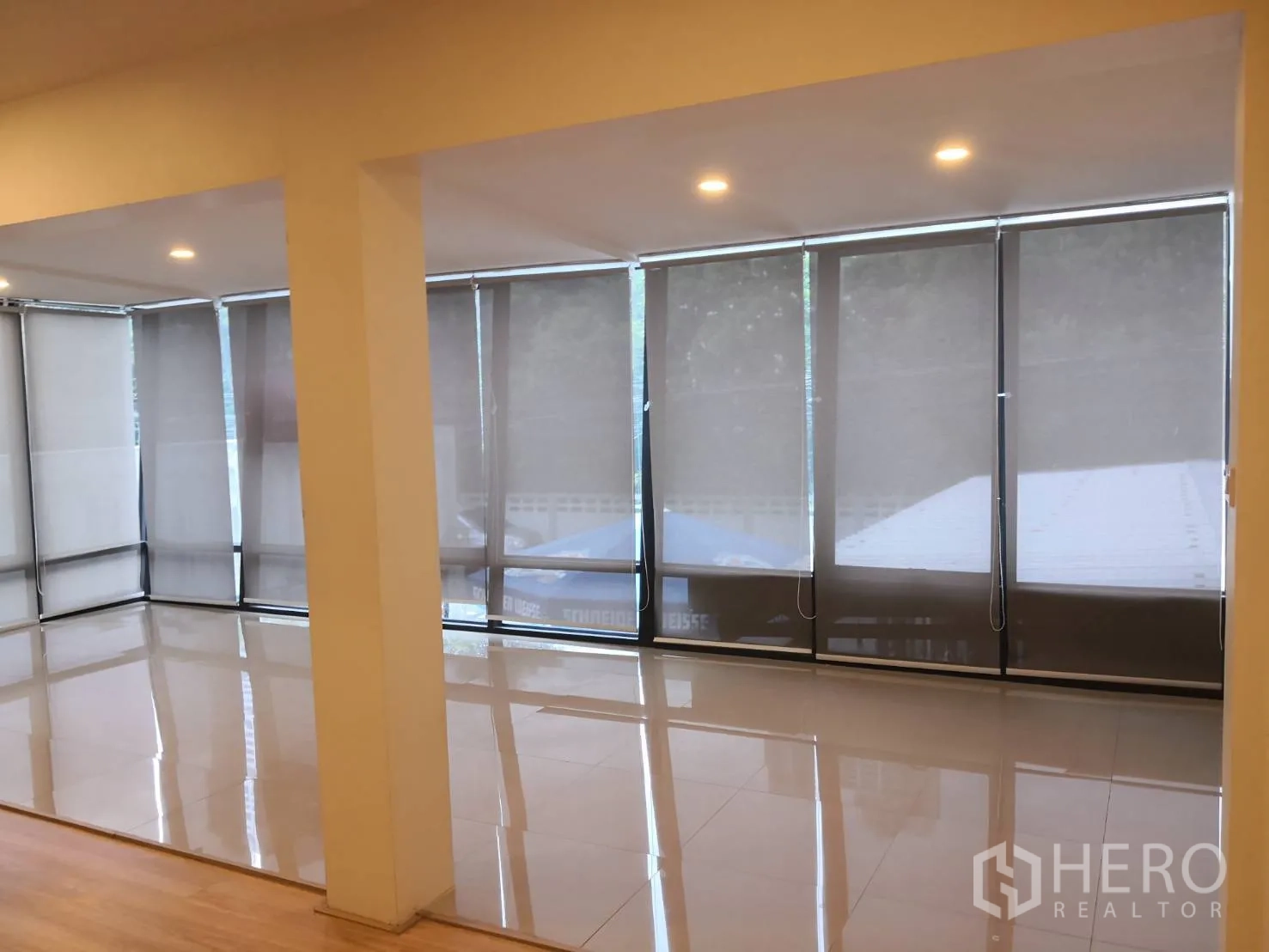 独栋房屋 for rent in Watthana, Bangkok - 转角客厅带环绕落地窗与抛光地砖。
