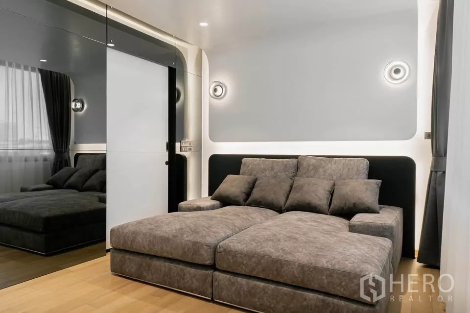 ทาวน์เฮาส์ ขายในChatuchak, Bangkok - ห้องมีเดียพร้อมโซฟาสีเทาและตู้เสื้อผ้าบานกระจกเงา