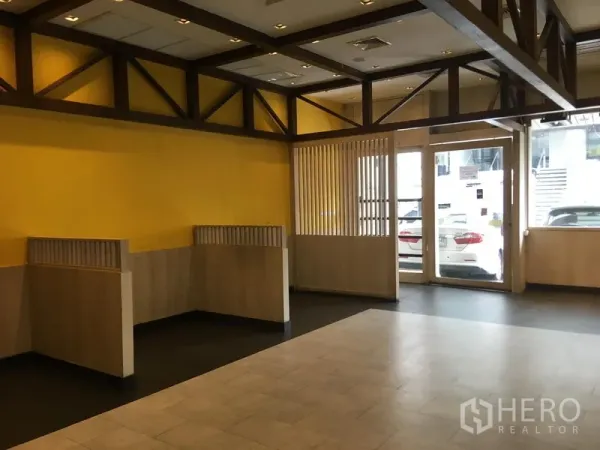 零售空间 出租在Khlong Toei, Bangkok - 卡座与隔断，入口附近配木梁装饰的天花。