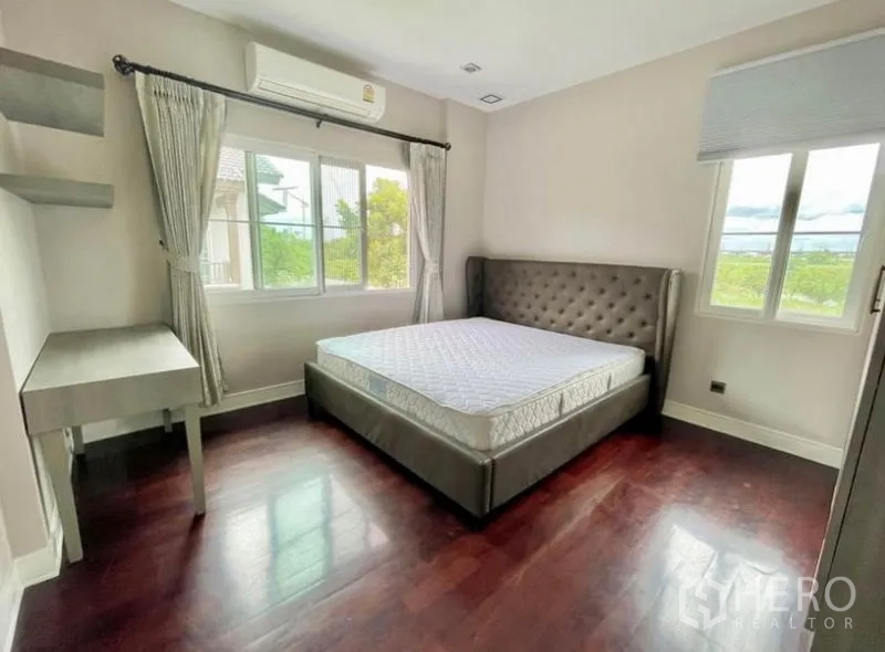 Detached House for rent in Bang Phli, Samut Prakan - Sunlit bedroom with corner windows, air conditioning and wood floors.