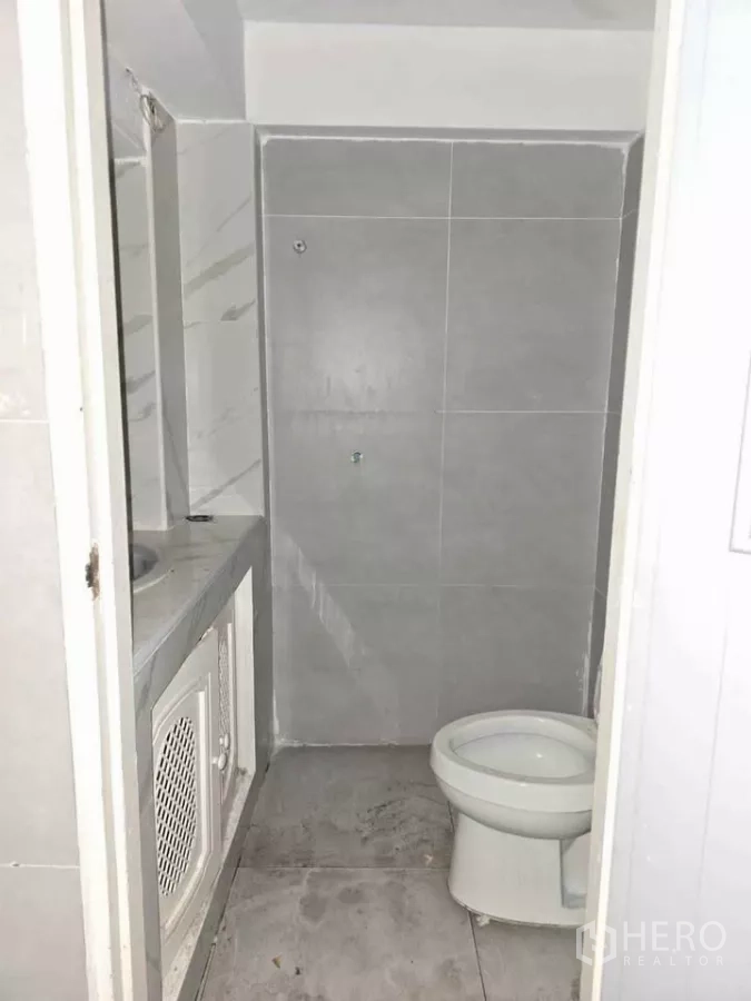 零售空间 出租在Watthana, Bangkok - 店内小型卫浴，灰色瓷砖，坐便与台上洗手台。