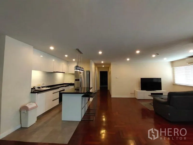 Condominium for rent or sale in Bang Rak, Bangkok - Expansive open‑plan interior showing kitchen, dining table, and TV lounge.