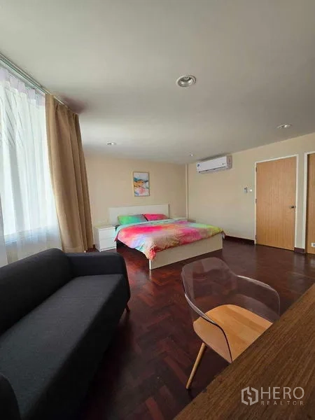 ทาวน์เฮาส์ ให้เช่าในBang Na, Bangkok - มุมห้องนอนพร้อมเครื่องปรับอากาศ โซฟา และโต๊ะทำงานบนพื้นไม้