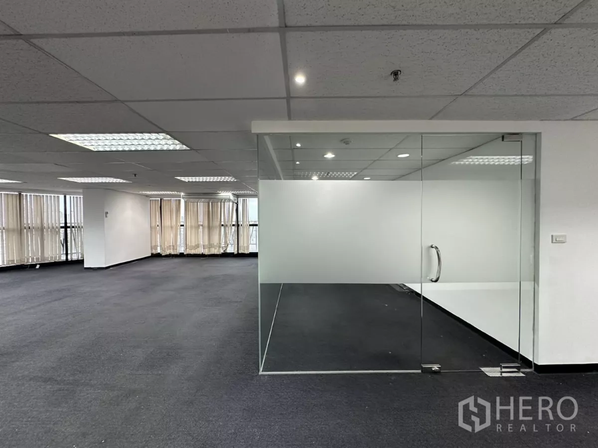 办公空间 出租在Watthana, Bangkok - 带磨砂带的玻璃会议室近景，铰链玻璃门、地毯与射灯。