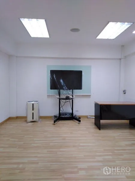 Office Space for sale in Bang Kapi, Bangkok - Open-plan workspace fitted with wooden cubicles, red chairs and fluorescent lights.