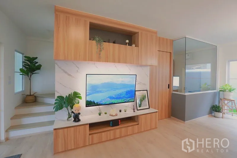 ทาวน์เฮาส์ ให้เช่าในPrawet, Bangkok - ผนังทีวีลายหินอ่อนพร้อมตู้เก็บของบิลท์อินไม้ ถัดจากบันได