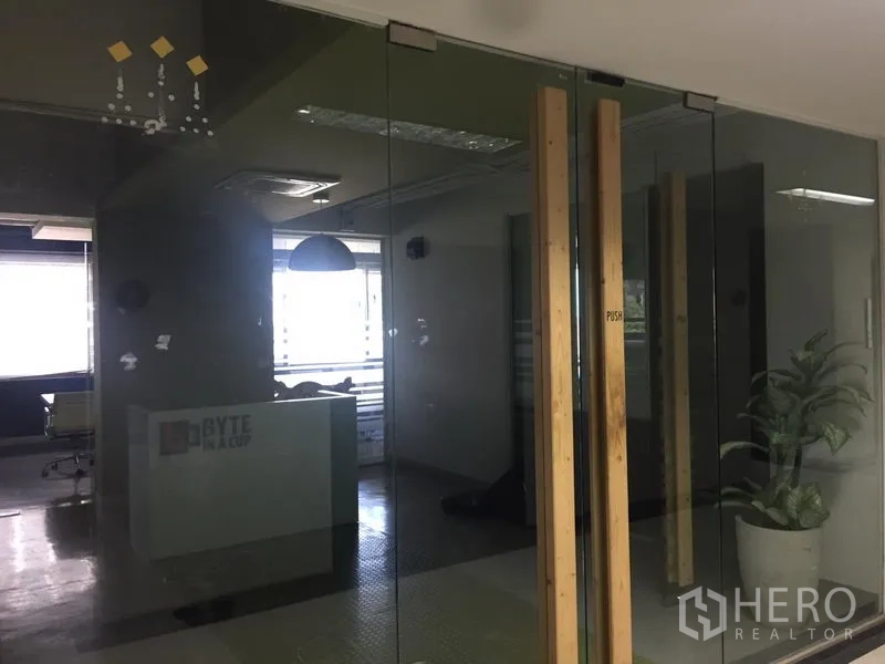 สำนักงาน ให้เช่าในBang Kapi, Bangkok - โถงต้อนรับหลังผนังกระจก มีหน้าต่างบานใหญ่ ไฟฝ้า และต้นไม้ในร่ม