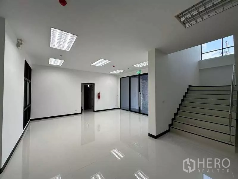 คลังสินค้า ให้เช่าในChon Buri - โถงสำนักงาน ประตูกระจกและบันไดขึ้นชั้นบนภายในโกดัง