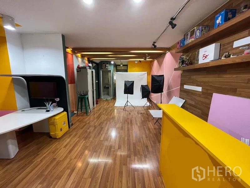 Home Office for sale - Multipurpose studio with wooden floor, shelves and photography backdrop lighting.