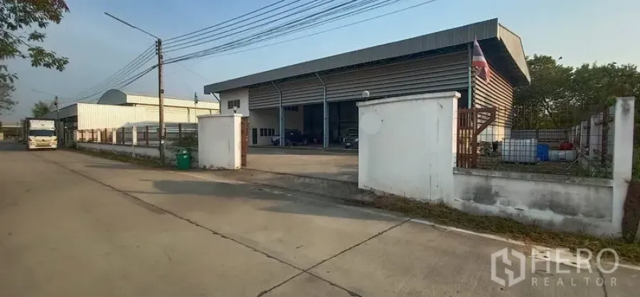 货栈 出租在Khlong Luang, Pathum Thani - 街边大门与围墙前的金属外墙仓库，车道宽敞。