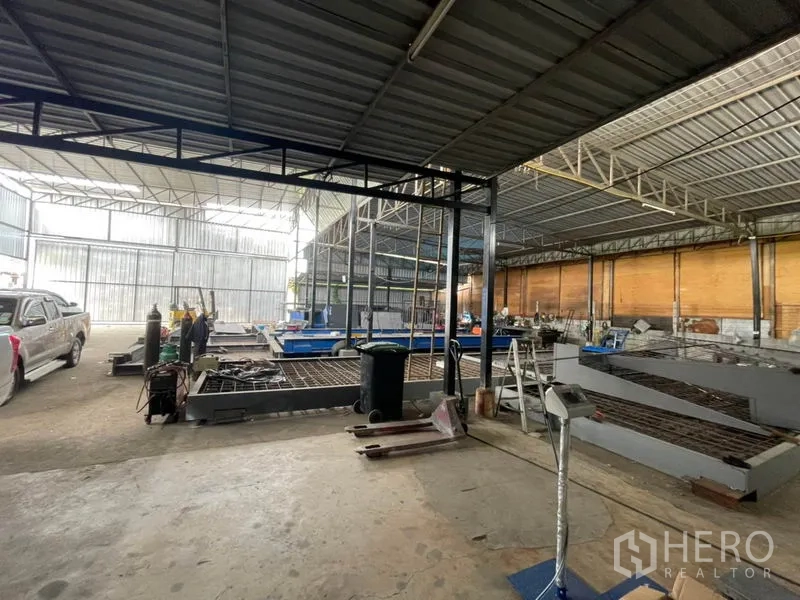 货栈 出租或出售在Khlong Luang, Pathum Thani - 室内视角，连续遮棚与通风面板，车辆与储存空间充裕。